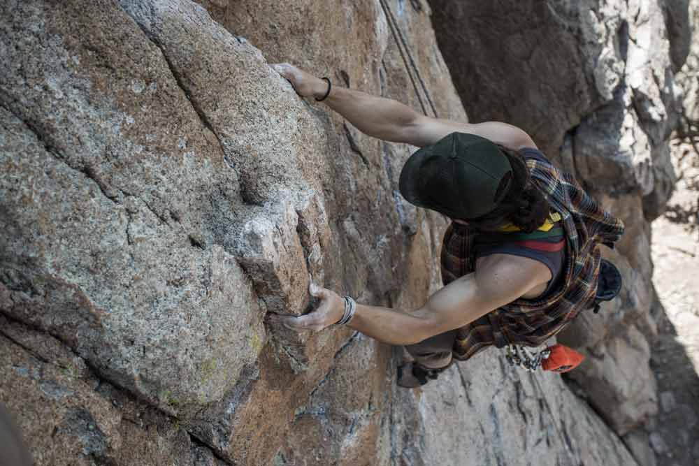 Man climbing mountain with male thigh chafing